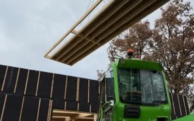 Extension en cours d&rsquo;une école : pose des murs ossature bois, caisson de toiture et isolation paille